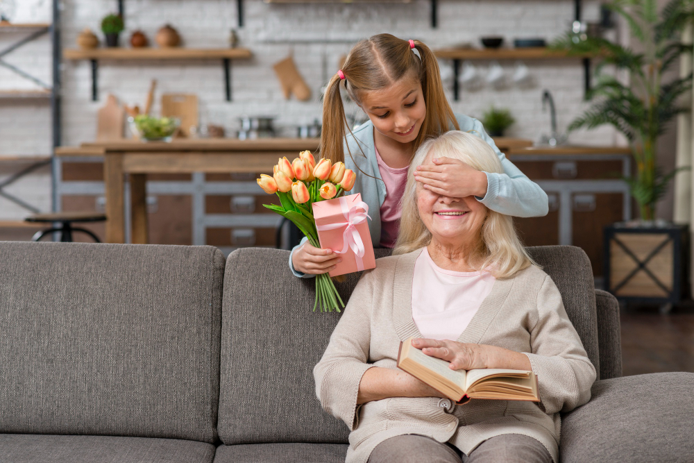Presente de Dia das Mães: foto de uma jovem garota neta cobrindo os olhos da avó enquanto se prepara para lhe entregar flores e uma lembrança